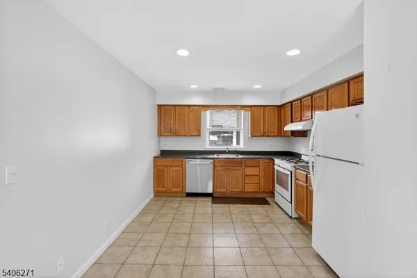 a kitchen with stainless steel appliances granite countertop a refrigerator a sink and dishwasher