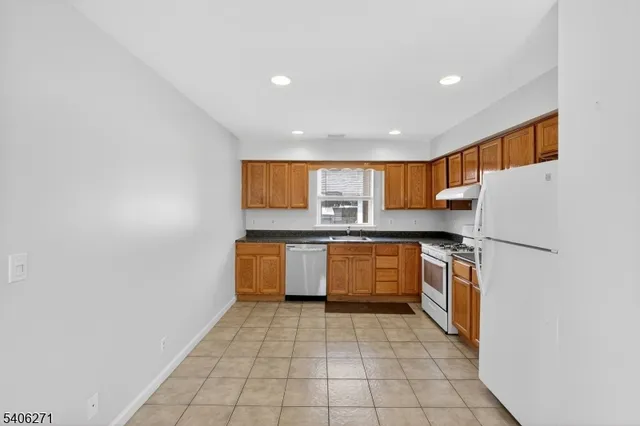 a kitchen with stainless steel appliances granite countertop a refrigerator a sink and dishwasher