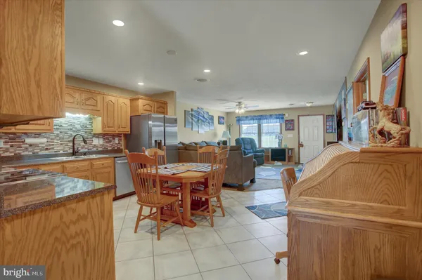 a living room with furniture and a dining table with kitchen view