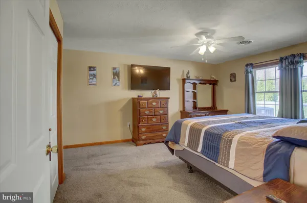 a spacious bedroom with a bed and a flat screen tv