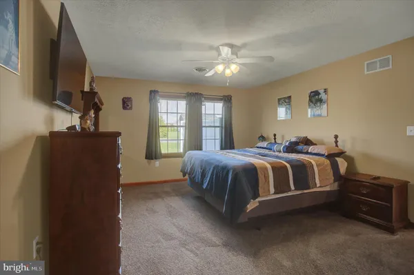 a spacious bedroom with a bed and a flat screen tv
