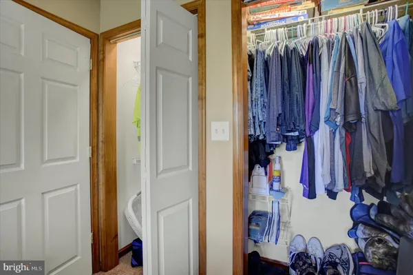a view of walk in closet with clothes and shoes