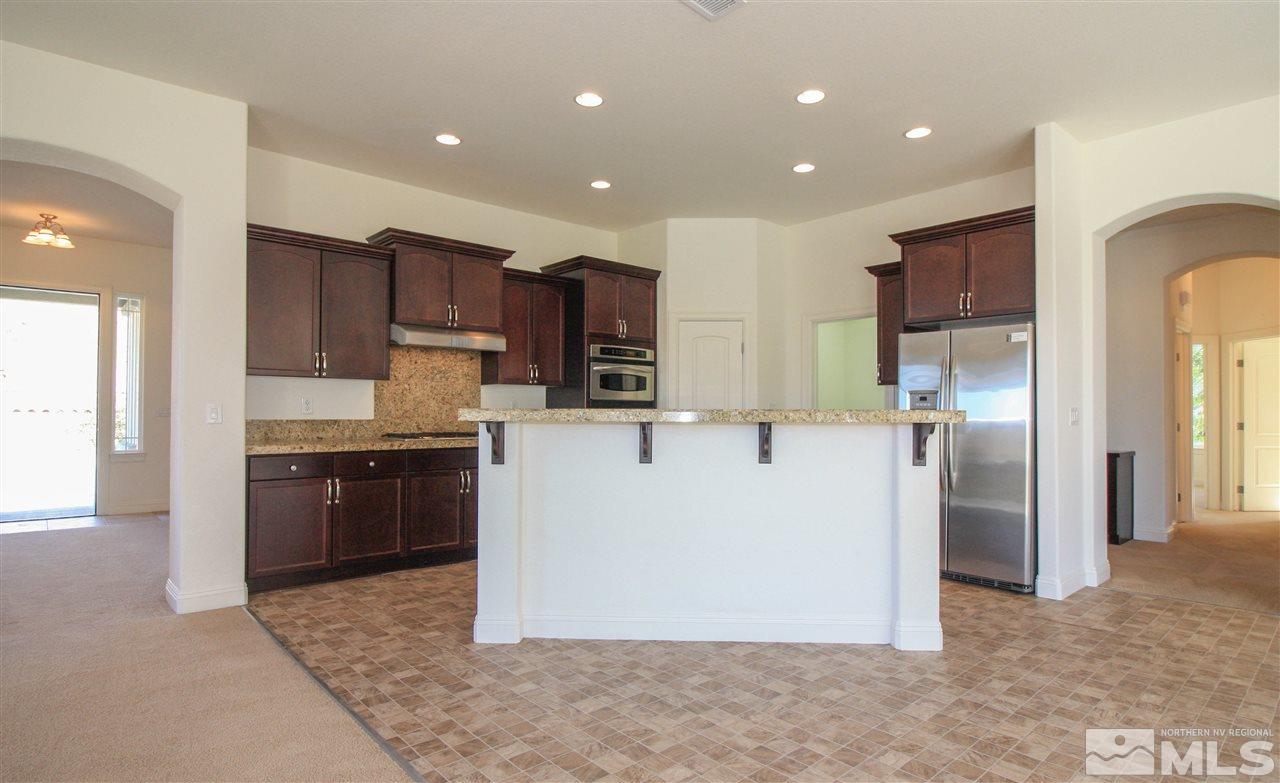 7505 Rough Rock Drive Reno, NV 89502 - Photo 11 of 25 a large kitchen with stainless steel appliances granite countertop a refrigerator and a stove top oven