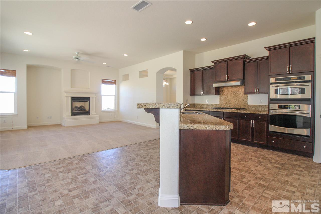 7505 Rough Rock Drive Reno, NV 89502 - Photo 8 of 25 a kitchen with stainless steel appliances granite countertop a refrigerator a stove and a sink