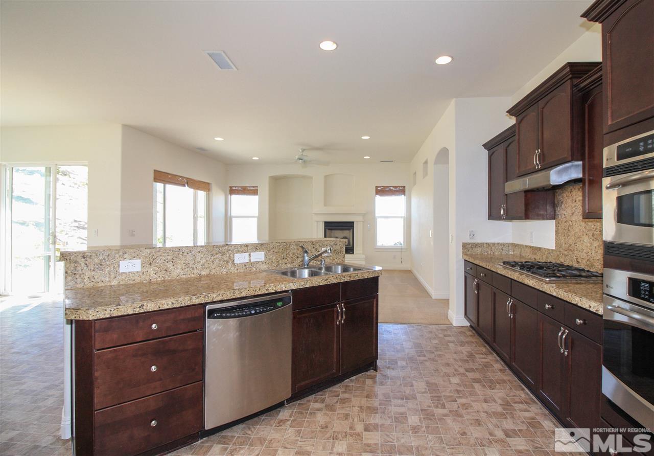 7505 Rough Rock Drive Reno, NV 89502 - Photo 9 of 25 a large kitchen with stainless steel appliances granite countertop a sink and cabinets
