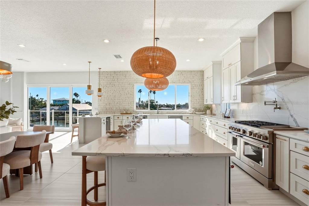 534 Crystal Drive Madeira Beach, FL 33708 - Photo 6 of 68 a kitchen with stainless steel appliances granite countertop a stove a sink a oven a dining table and chairs