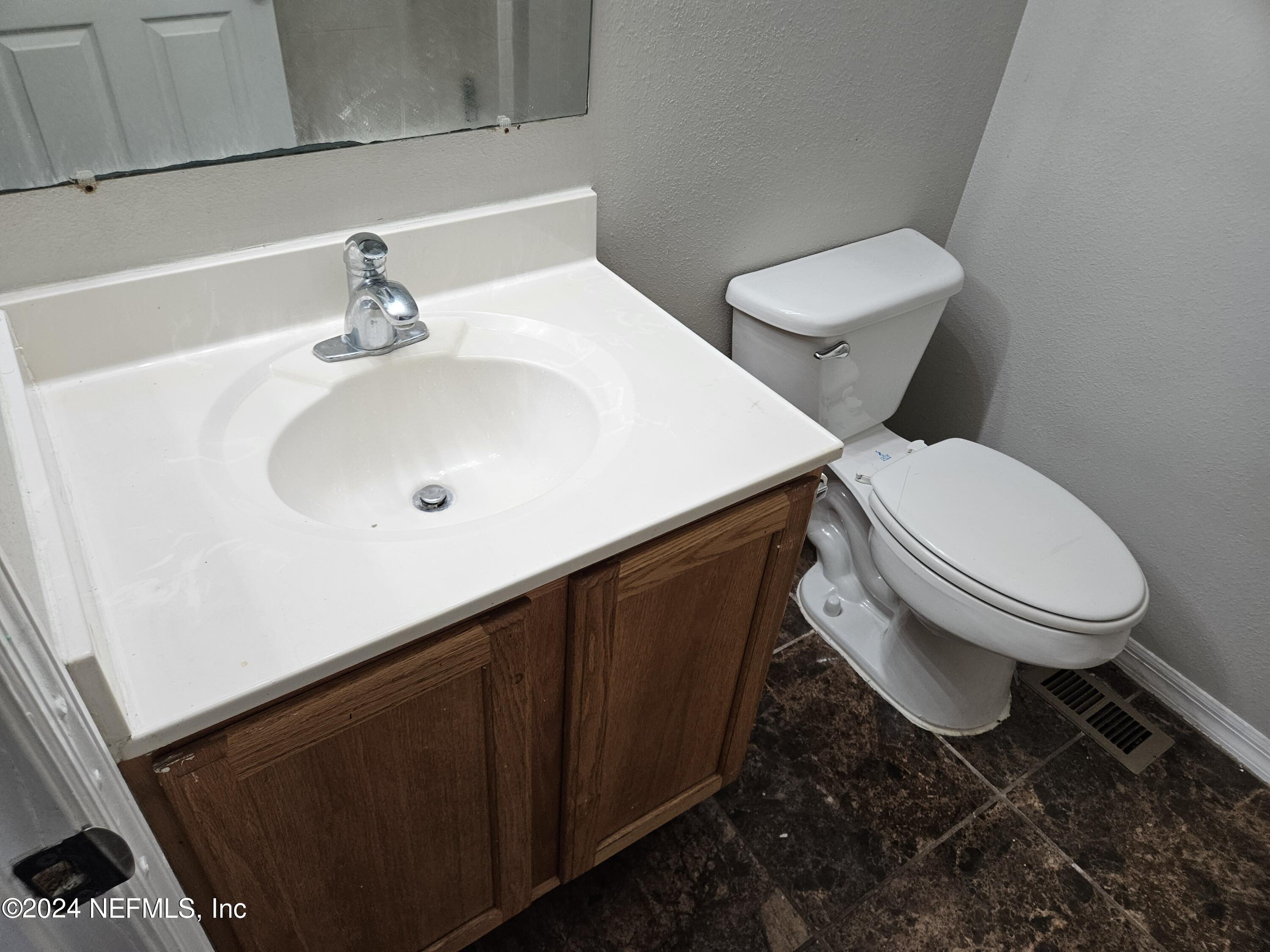711 Talking Tree Drive Jacksonville, FL 32205 - Photo 45 of 61 a white toilet sitting next to a bathroom sink