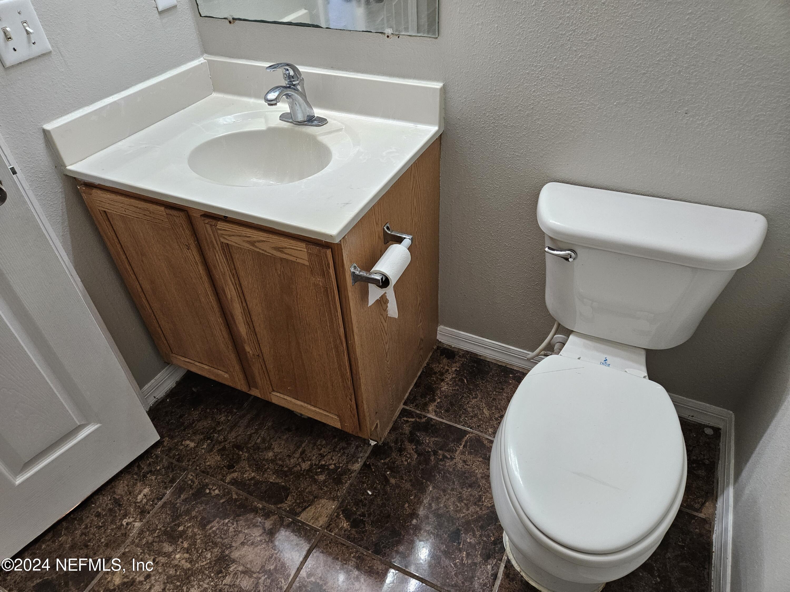 711 Talking Tree Drive Jacksonville, FL 32205 - Photo 48 of 61 a bathroom with a toilet sink and mirror