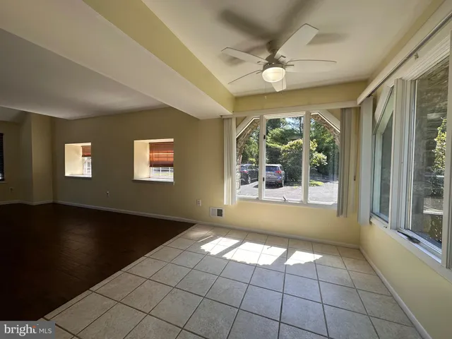 a view of an empty room with wooden floor and a floor to ceiling window