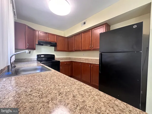 a kitchen with stainless steel appliances granite countertop a refrigerator sink and cabinets