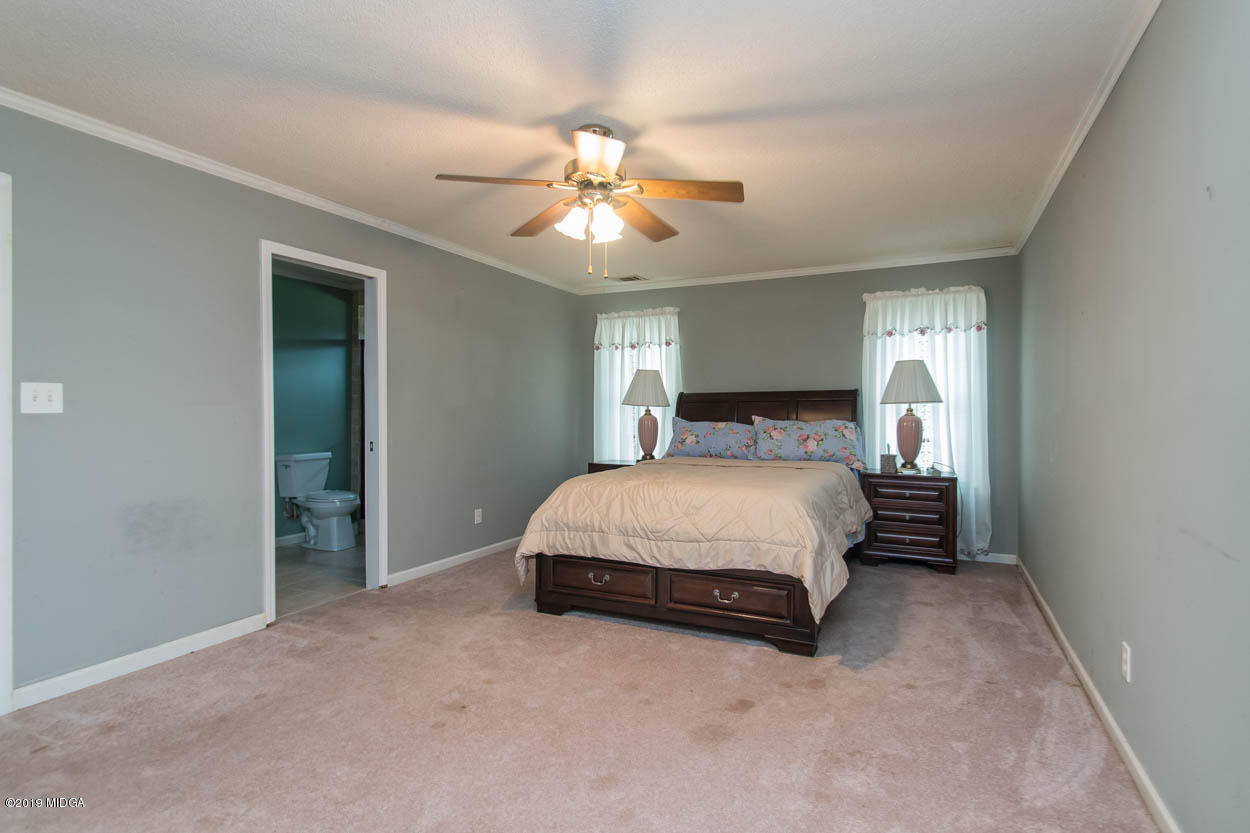 2725 Moseley Road Byron, GA 31008 - Photo 30 of 34 a spacious bedroom with a bed and a ceiling fan
