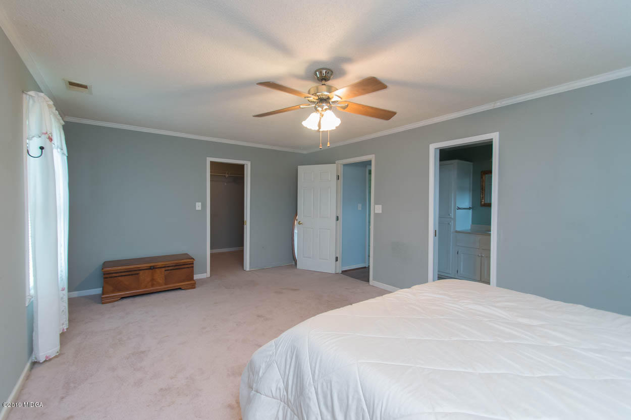 2725 Moseley Road Byron, GA 31008 - Photo 31 of 34 a bedroom with a bed and a chandelier