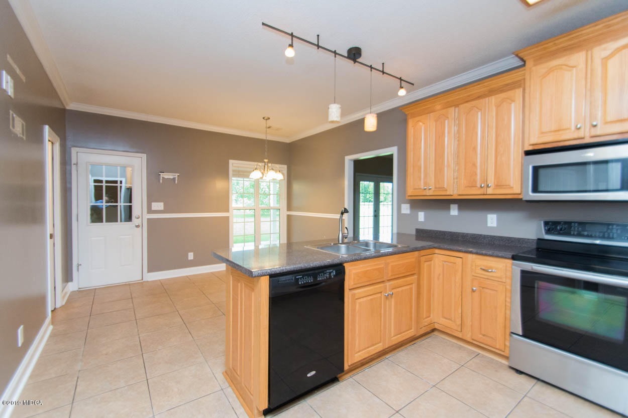 2725 Moseley Road Byron, GA 31008 - Photo 6 of 34 a kitchen with stainless steel appliances granite countertop a stove a sink and a microwave