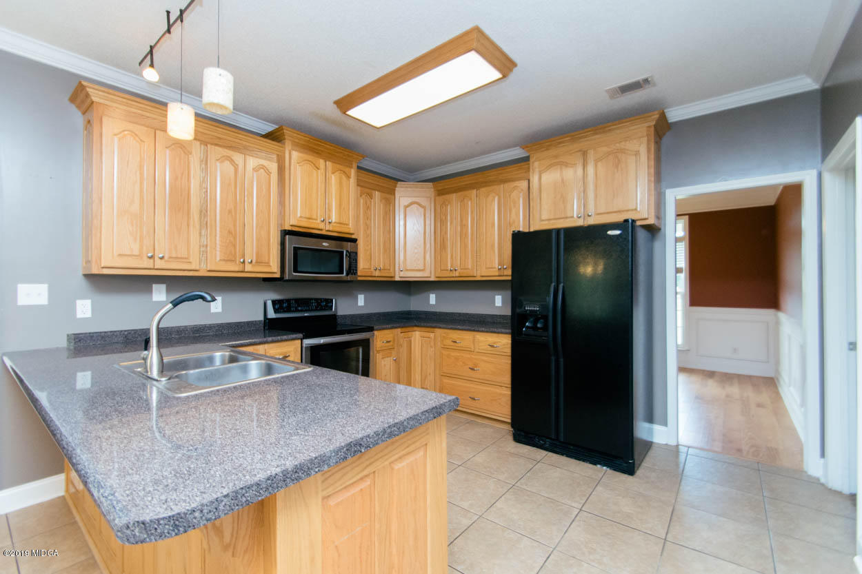 2725 Moseley Road Byron, GA 31008 - Photo 7 of 34 a kitchen with granite countertop a refrigerator a stove a sink a microwave and island