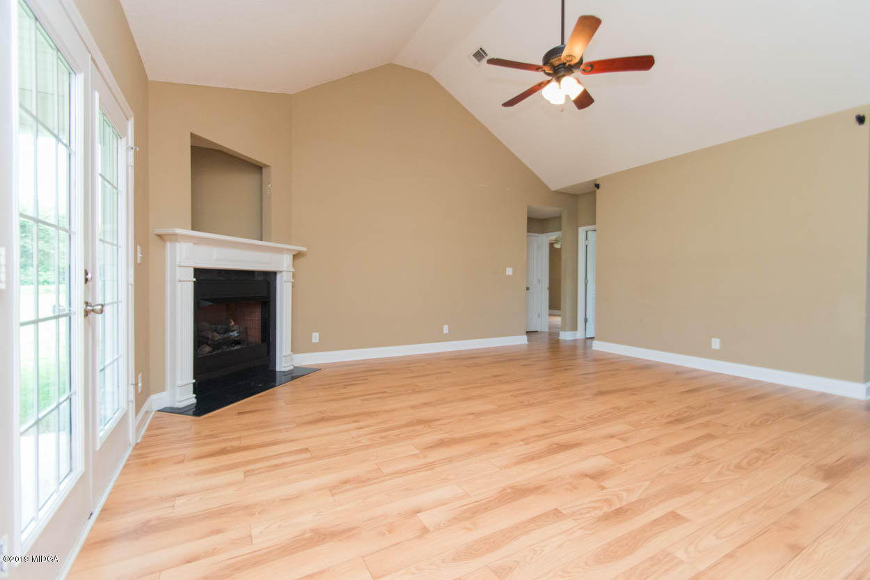 2725 Moseley Road Byron, GA 31008 - Photo 10 of 34 a view of a room with a ceiling fan and a fireplace