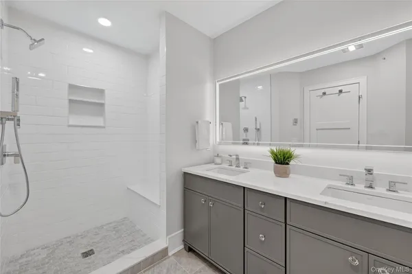 a bathroom with a granite countertop sink mirror and shower