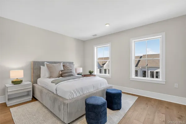 a spacious bedroom with a bed and wooden floor