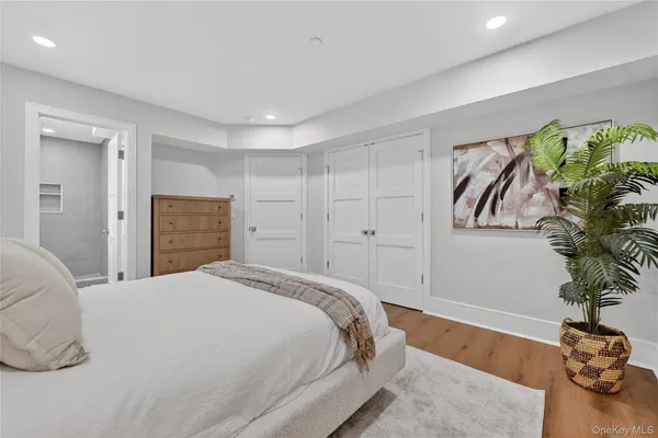 a spacious bedroom with a bed and a potted plant