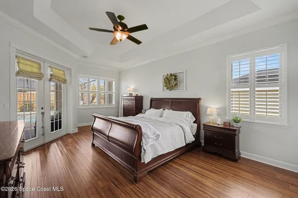 a bedroom with a bed a window and a chandelier