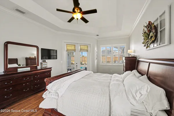 a bedroom with a bed and a flat tv screen on the dresser