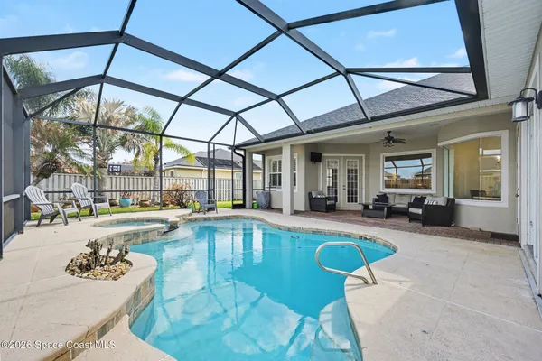 a view of a swimming pool with a dining table and chairs