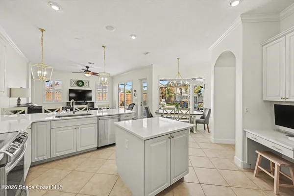 a large white kitchen with a sink and cabinets