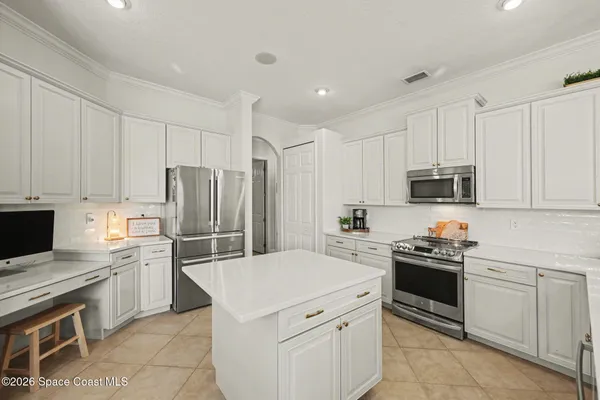 a kitchen with white cabinets and stainless steel appliances