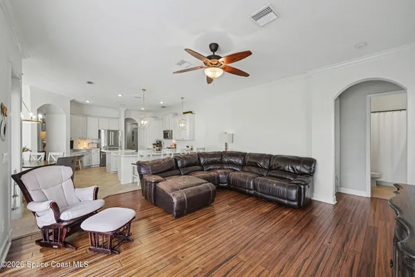 a living room with furniture and a wooden floor