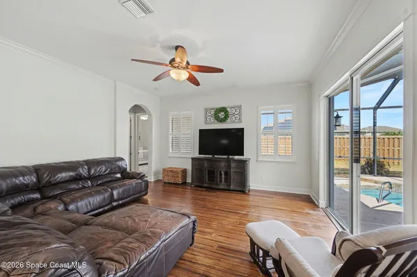 a living room with furniture a flat screen tv and a large window