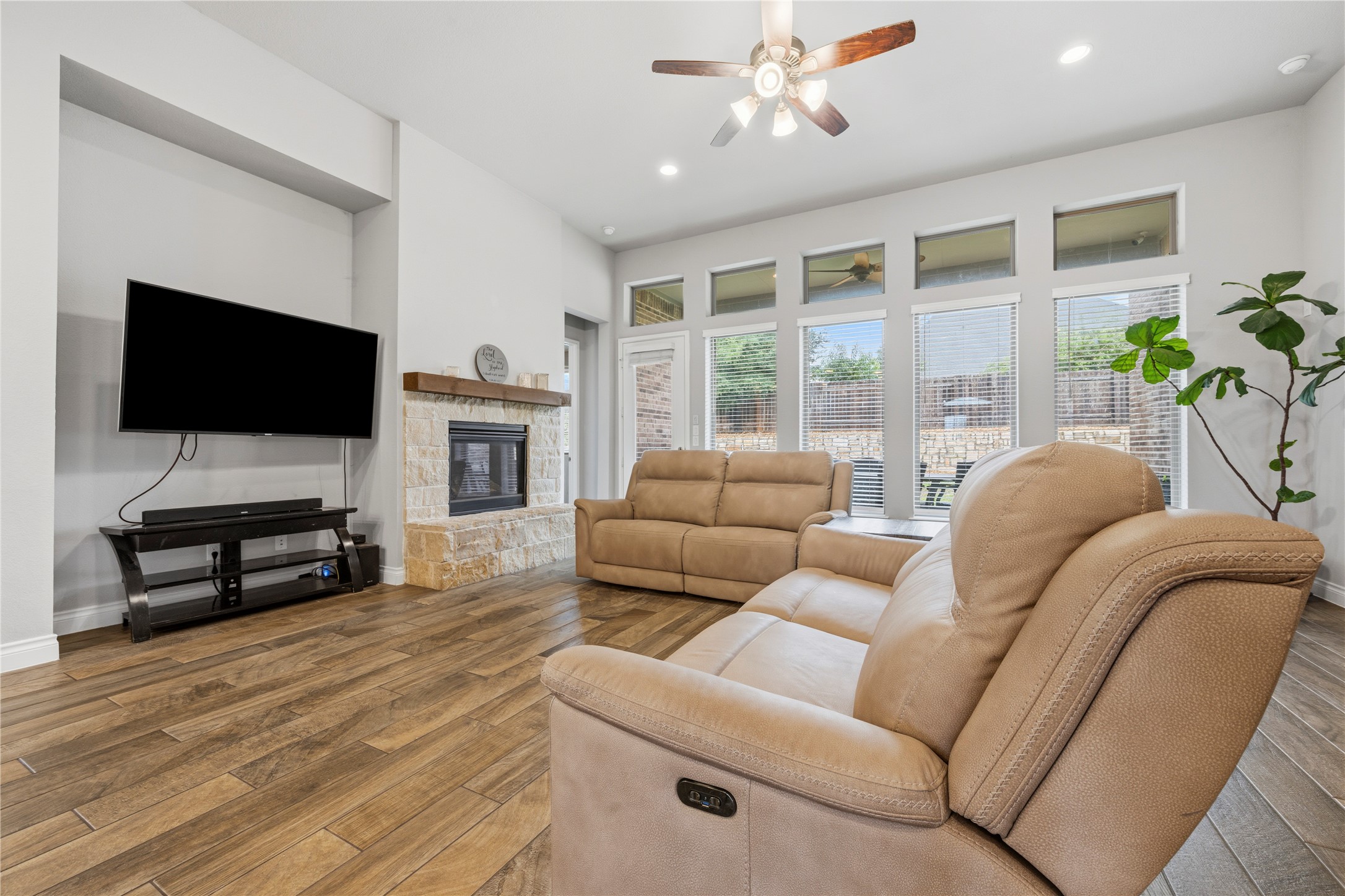 140 Catani Loop Georgetown, TX 78628 - Photo 10 of 36 A comforting living area with warm wood flooring and a classic stone fireplace.