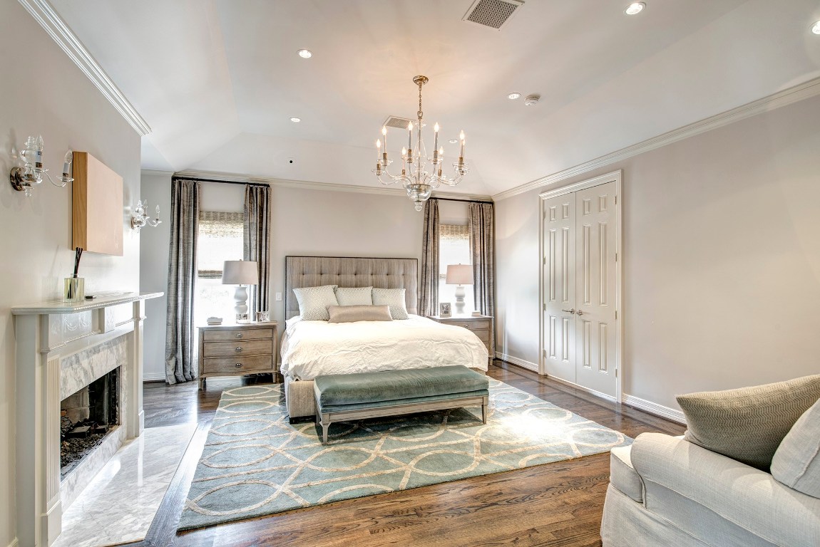 3440 Locke Lane Houston, TX 77027 - Photo 14 of 21 a bedroom with a large bed a flat tv screen and a fireplace