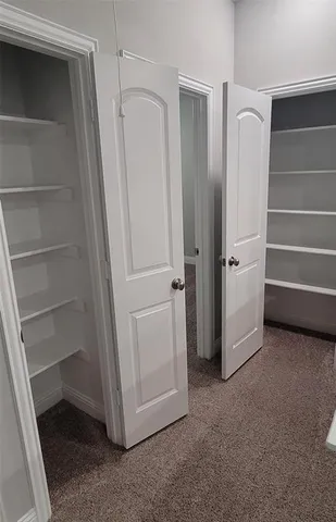 a view of walk in closet with empty racks