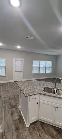 a kitchen with granite countertop a sink and cabinets