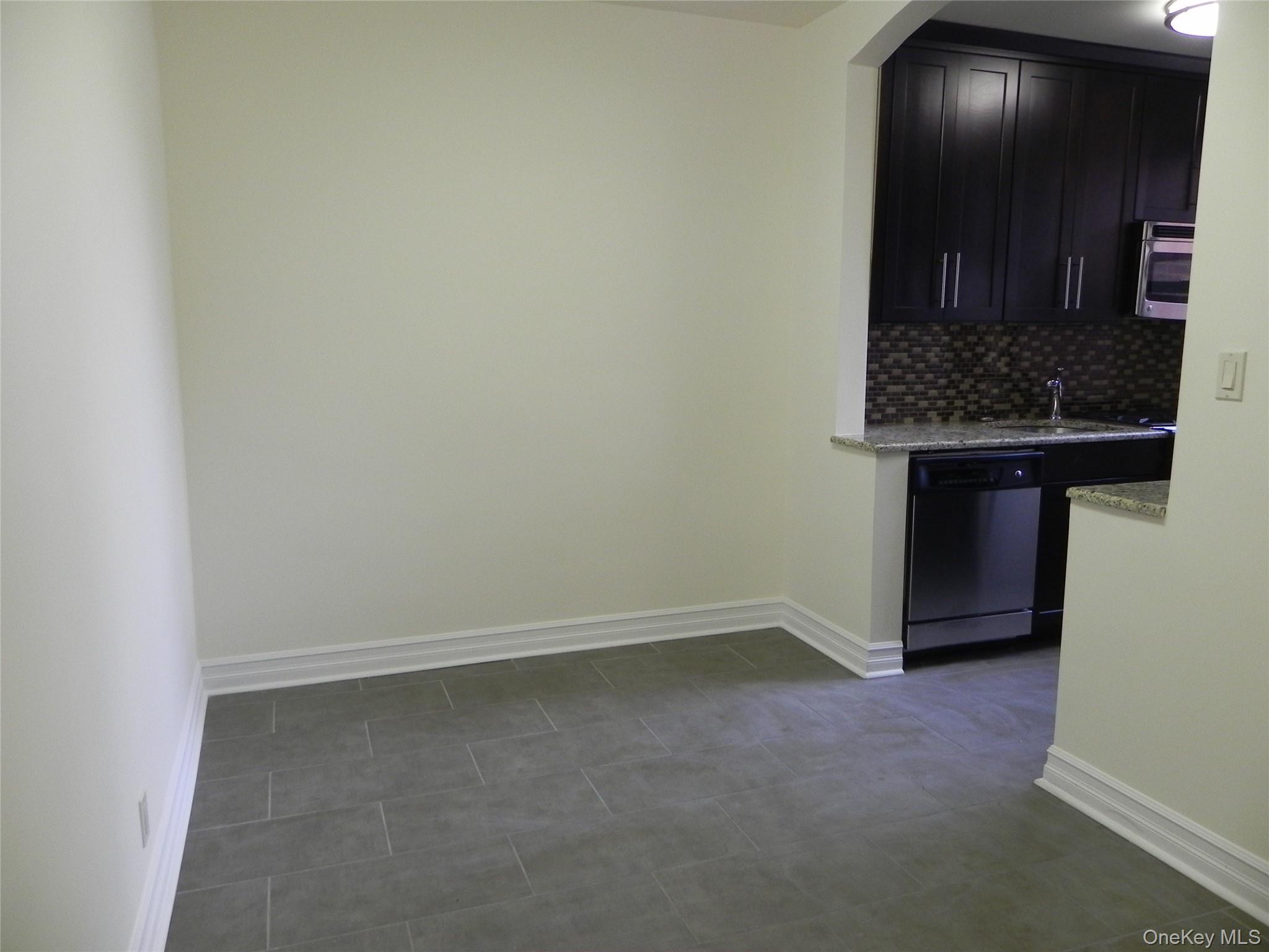 160 South Middle Neck Road, Unit 1N Great Neck, NY 11021 - Photo 8 of 15 Kitchen with light stone counters, tile backsplash, and stainless steel appliances