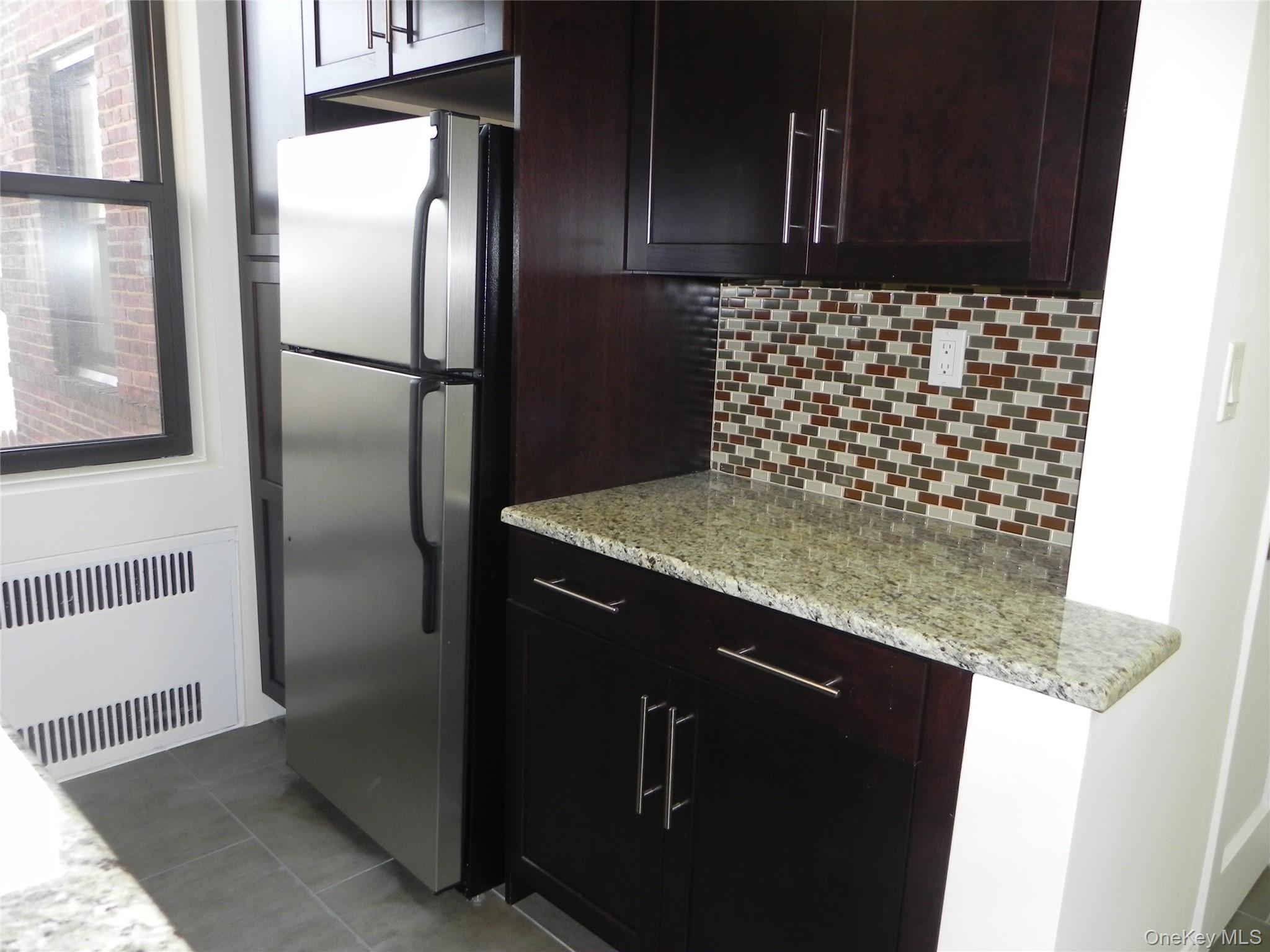 160 South Middle Neck Road, Unit 1N Great Neck, NY 11021 - Photo 10 of 15 Dark brown wood cabinetry throughout kitchen
