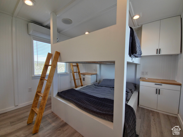 900 Altamont Road Evanston, WY 82930 - Photo 15 of 27 Bedroom with light wood-style flooring and a wall unit AC