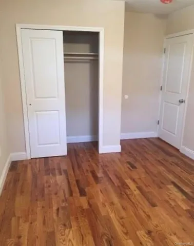 a view of an empty room with closet and a window
