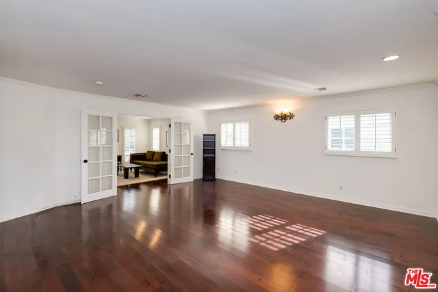 a view of empty room with wooden floor and window
