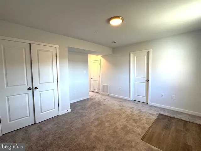 an empty room with windows and closet