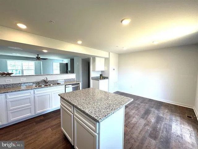 a kitchen with kitchen island a sink stove and refrigerator