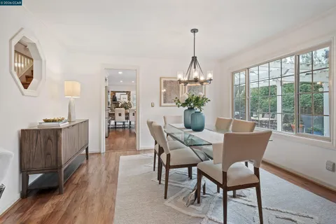 a dining room with furniture a chandelier and wooden floor