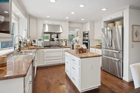 a kitchen with white cabinets and stainless steel appliances