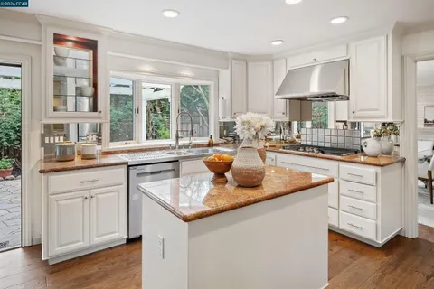 a kitchen with sink a window and chairs