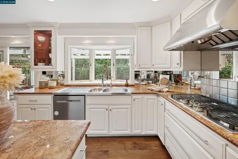 a kitchen with stainless steel appliances granite countertop a sink stove and cabinets