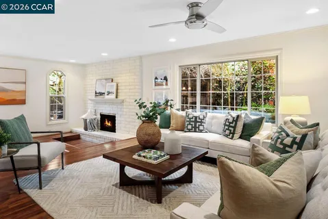 a living room with furniture fireplace and a large window