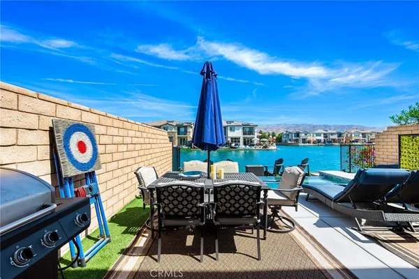 a view of a swimming pool and lounge chairs in back of a house