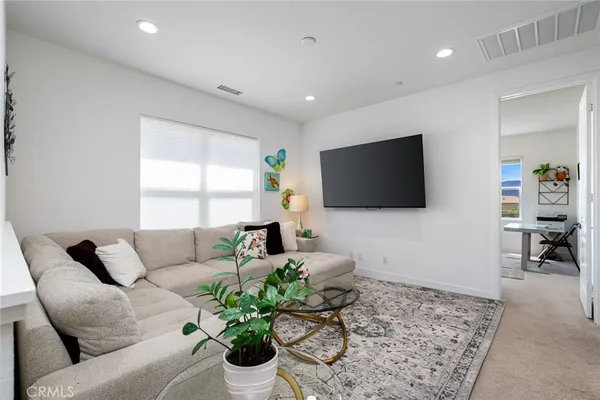 a bedroom with a bed and a flat tv screen on the dresser