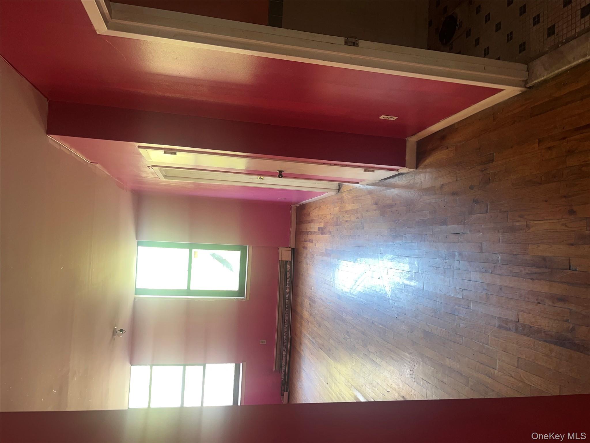 18 East 132nd Street, Unit 3A Manhattan, NY 10037 - Photo 8 of 11 an empty room with wooden floor and windows