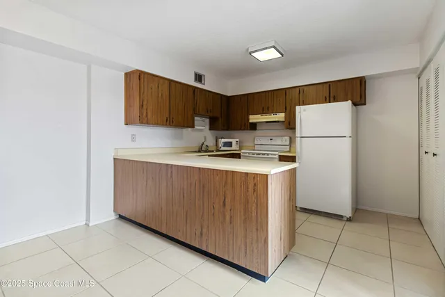a kitchen with a refrigerator sink and cabinets