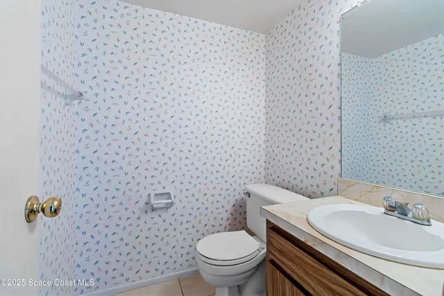 a bathroom with a granite countertop toilet and a sink